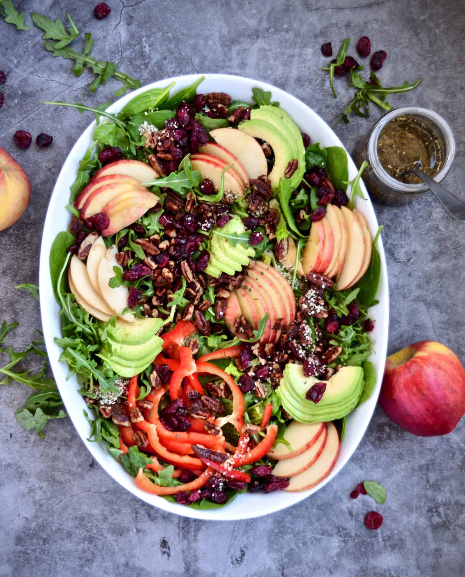 A vibrant Harvest Salad with Apples and Sweet Balsamic Vinaigrette in an oval dish.