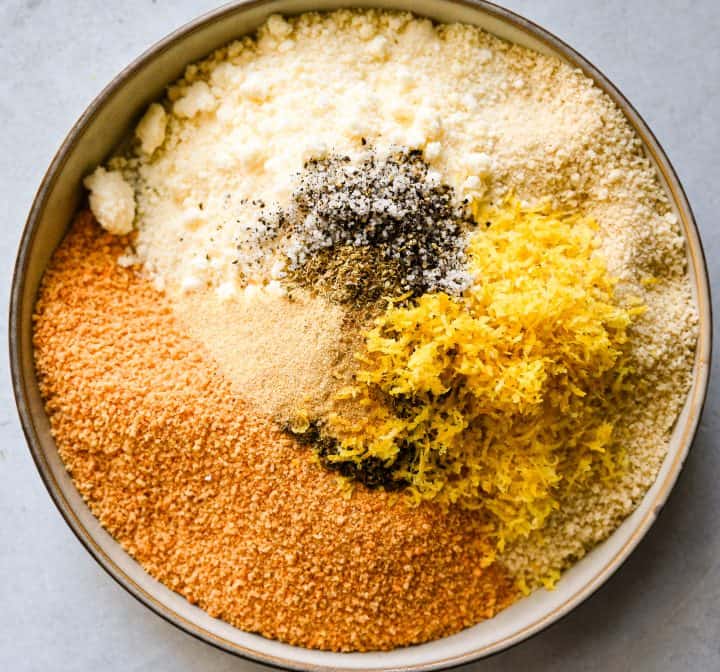Breadcrumb mixture with parmesan, lemon zest, garlic powder, and seasonings for crispy lemon garlic chicken cutlets.